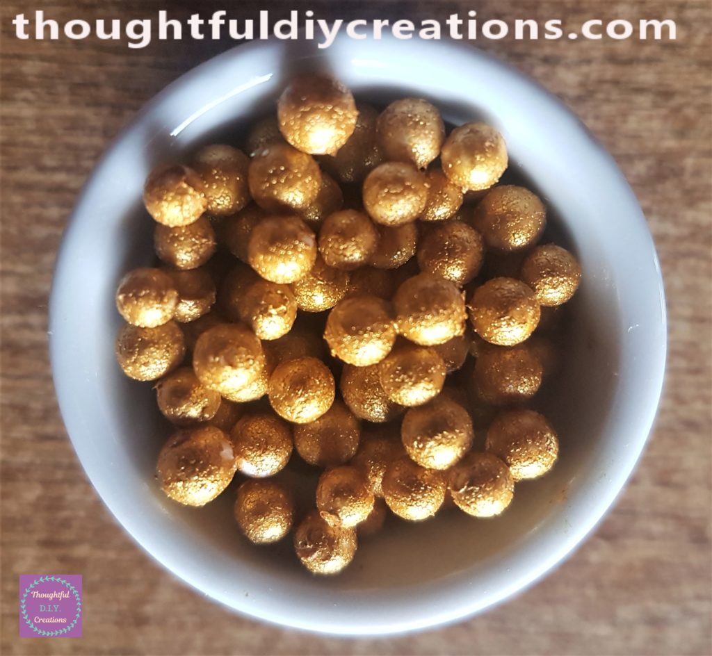 Front view of the gold mini balls in the candle holder.