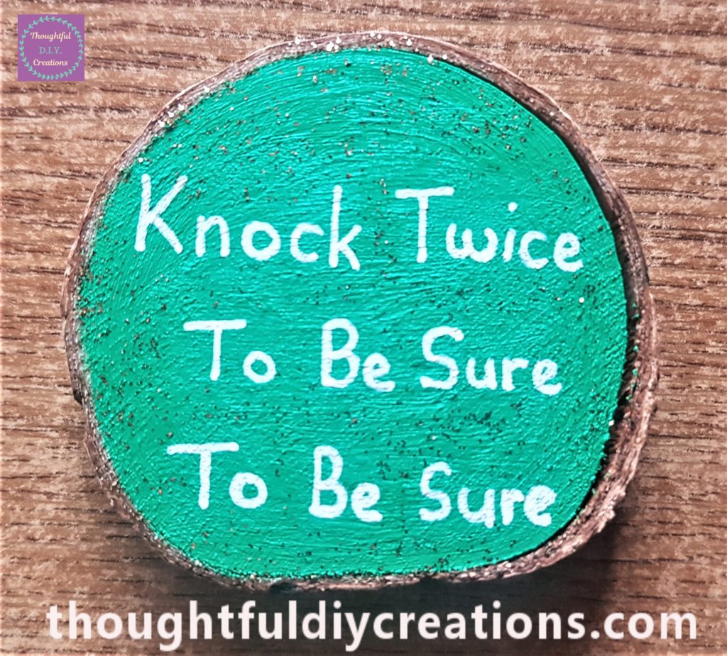 'Knock Twice To Be Sure To Be Sure' written on the Wood Slice with the white paint pen. Gold glitter eye liner added all over the wood slice.