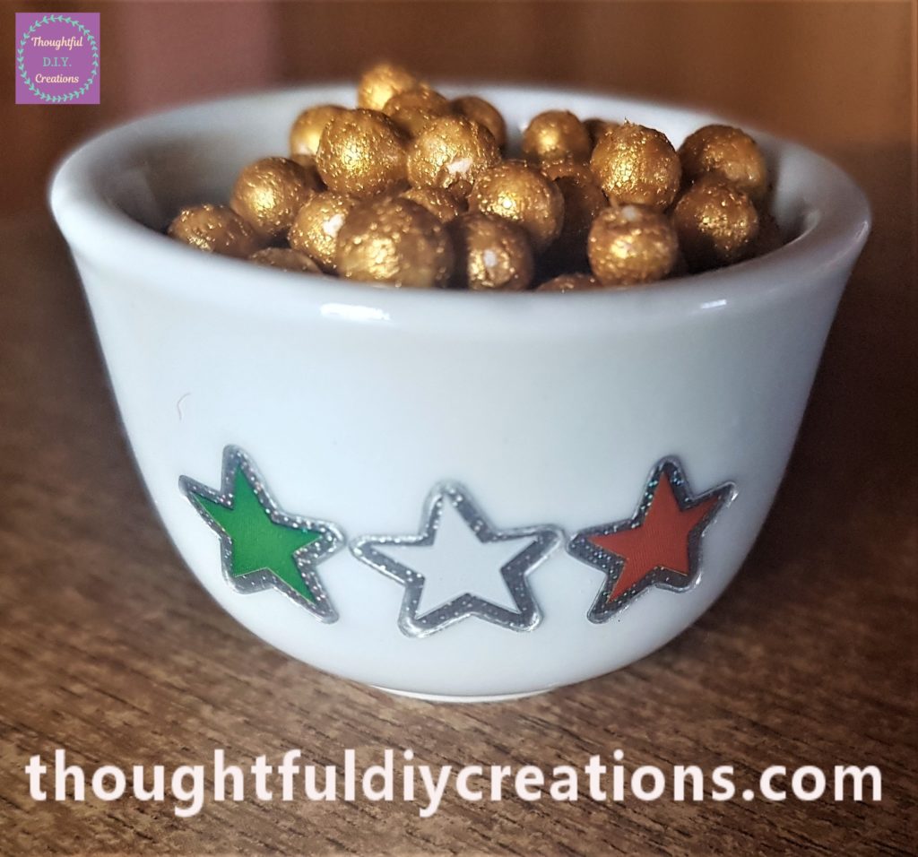 Green, white and orange star stickers added to the front of the candle holder.