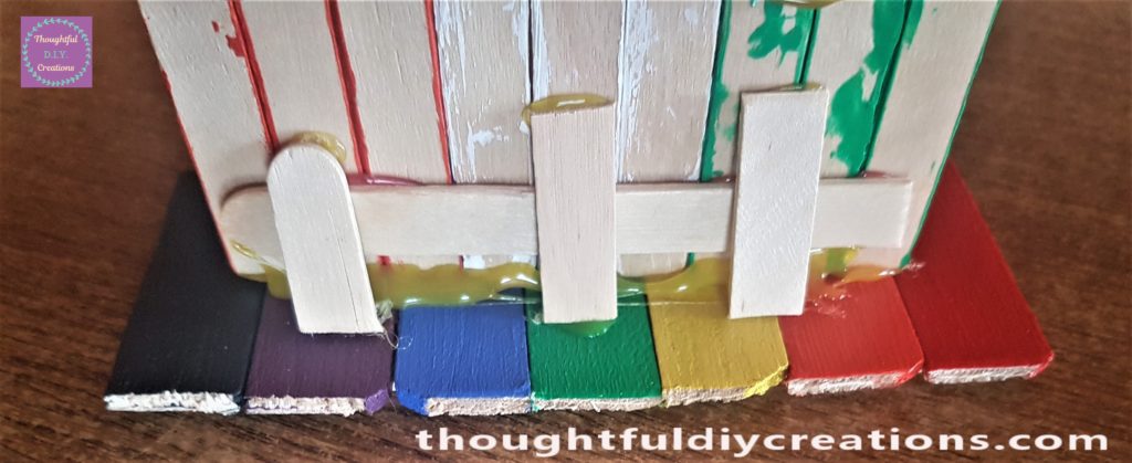 3 of the cut lollipop sticks hot glued to the back of the door and path to keep it secure.