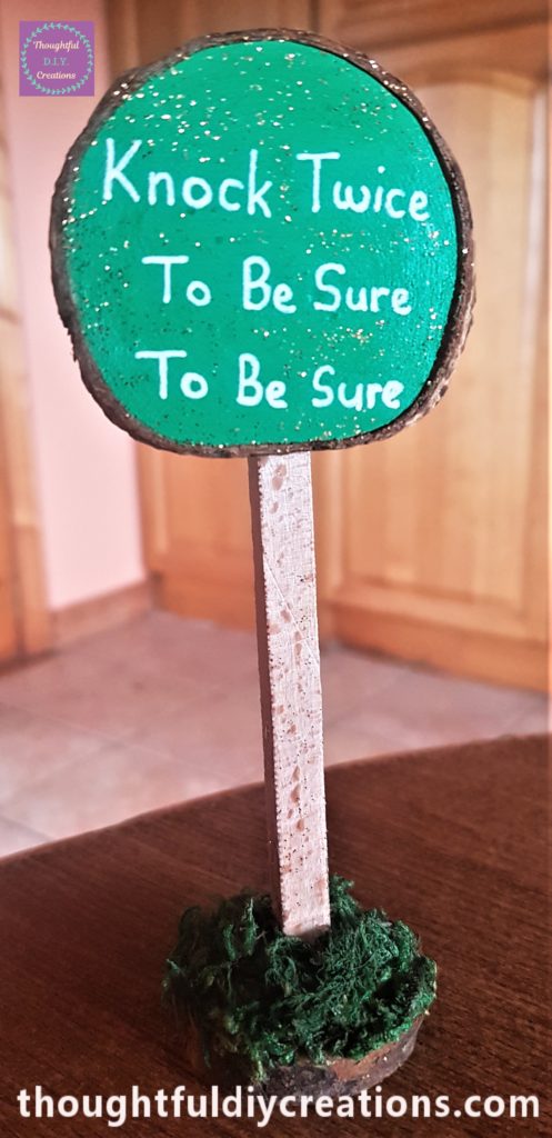 The green wood slice hot glued to the top of the wooden stick.