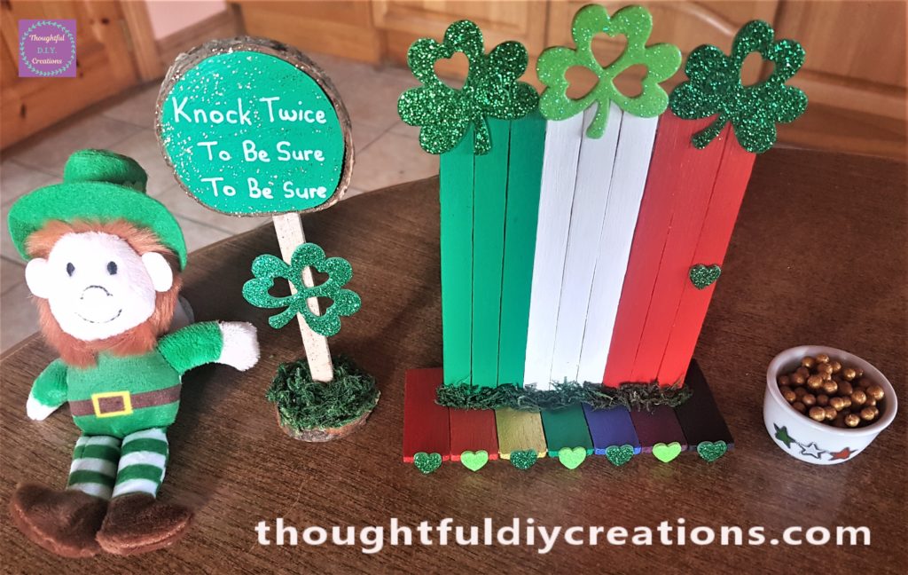 The leprechaun arranged beside the sign, door and crock of gold.