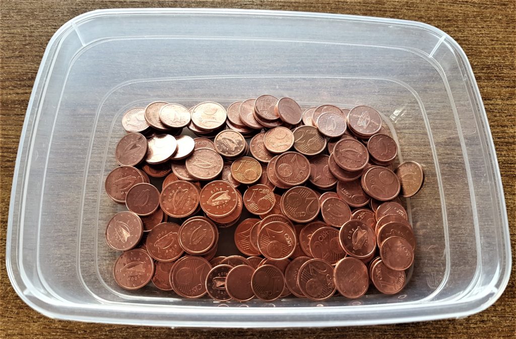 The coins in a different container after being dried with a teacloth.