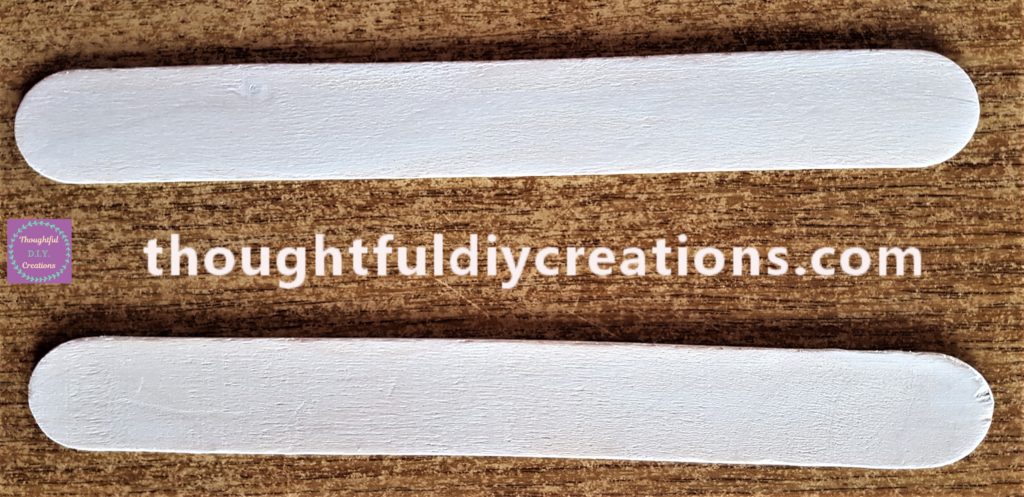 First layer of paint on the lollipop sticks.