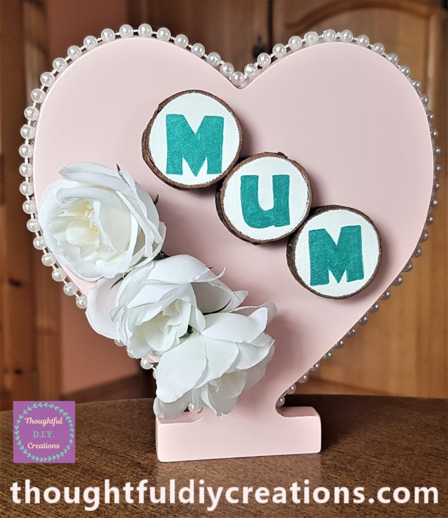 The heart standing upright with the wood slices hot glued to it.