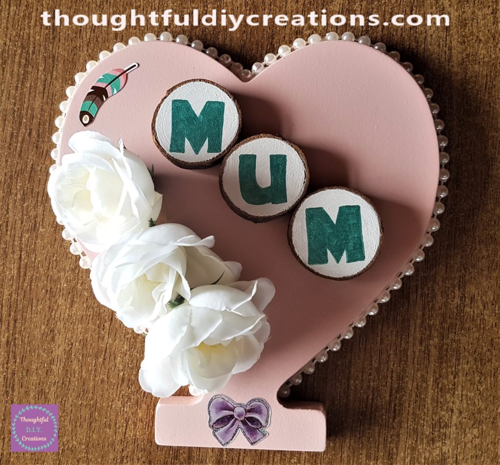 A sticker of a purple bow added to the mid-section on the bottom of the heart.