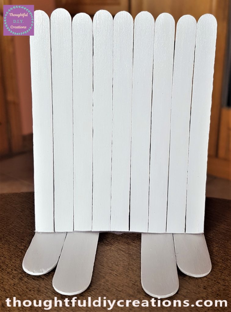 Hot glue on the bottom of the Easter Bunny Door and attached to the Bunny's feet.