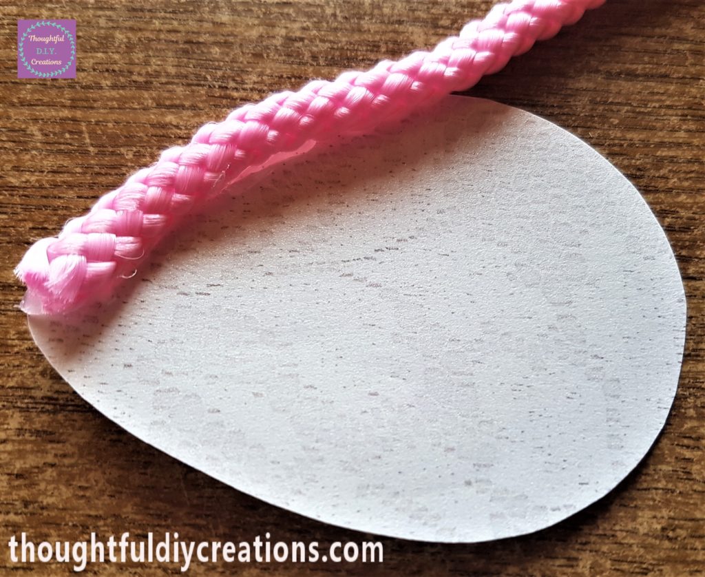 Hot glue on the back of the lace and attached to the edge of the lace paper.