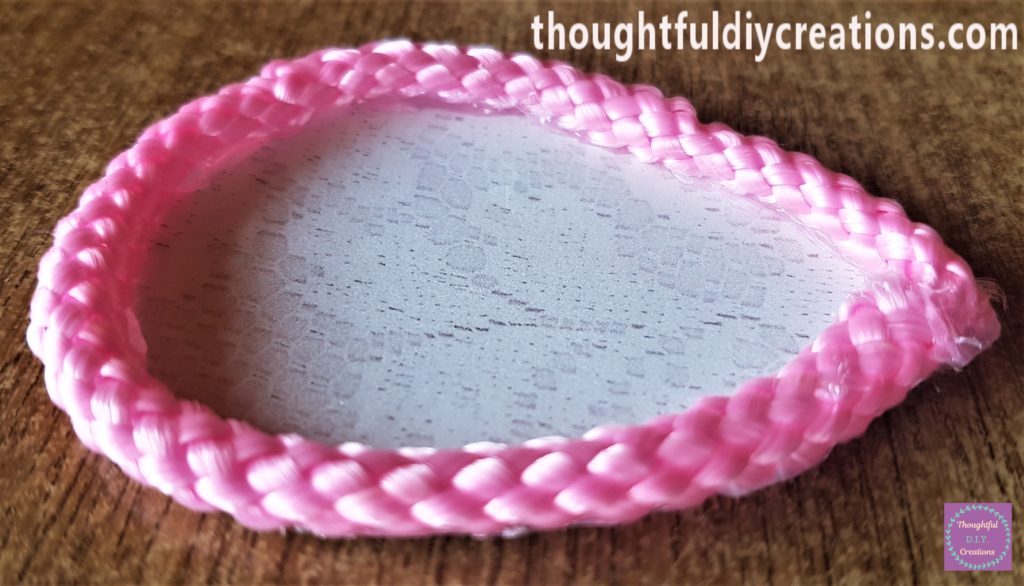 The pink lace hot glued to the lace paper to form the Bunny Ear. The excess lace was cut off and the 2 joining pieces hot glued together.