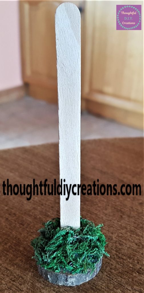 Dried moss hot glued to the wood slice.