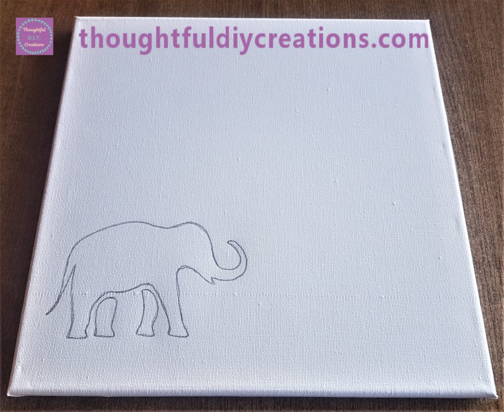 I drew around the outline of the elephant on the canvas with a dark pencil.