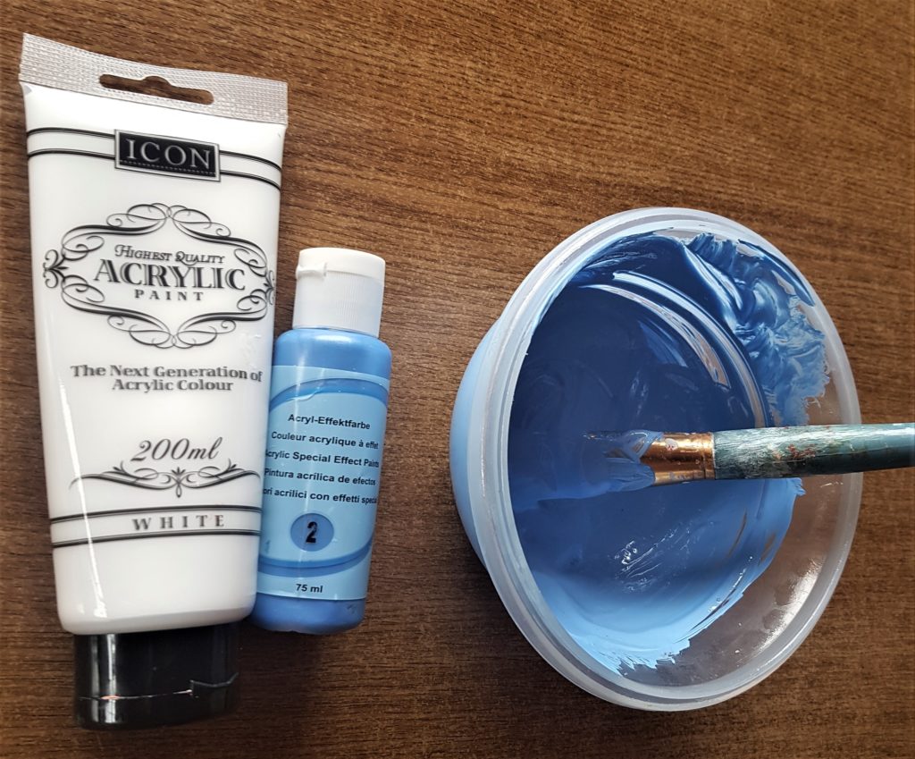 White acrylic paint mixed with Blue Acrylic paint to make a lighter shade of Blue.