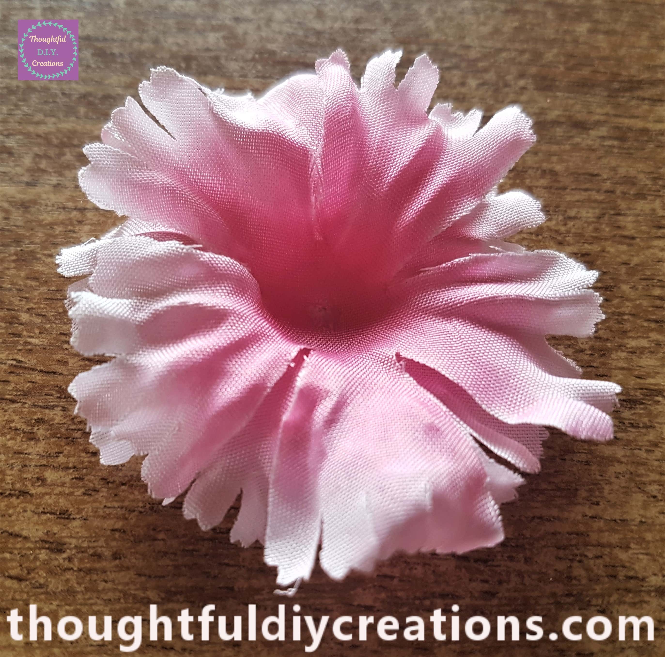 Clear hot glue added to the center of the largest petal, the center of the next size petal attached to the glue.