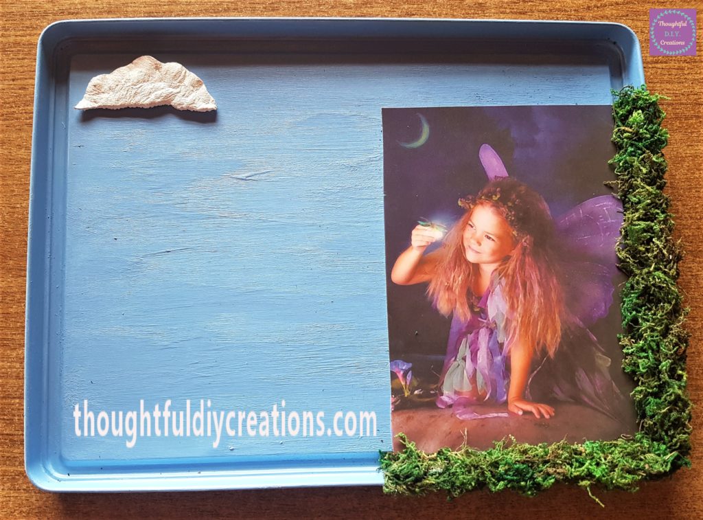 Hot glue on the back of the cloud and attached to the top of the lid.