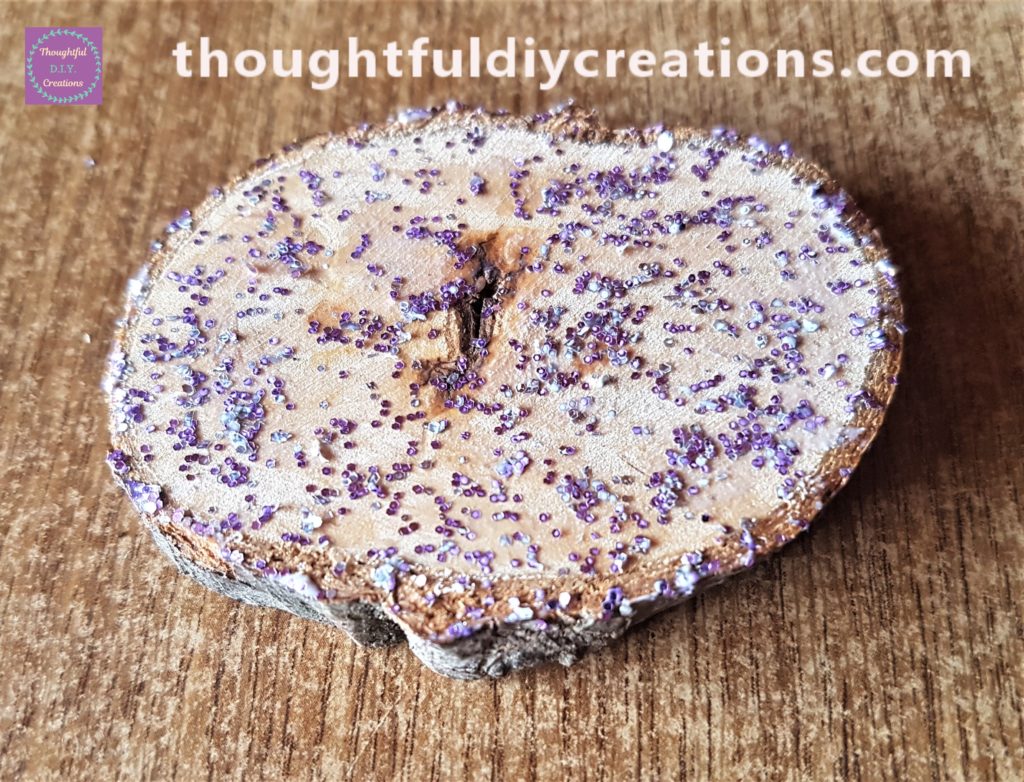 The glitter glue mixture added all around the wood slice with a small paintbrush.