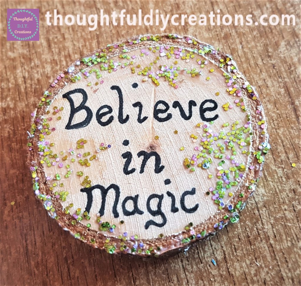 PVA Glue added to the glitter and put on the sides and top of the wood slice with a paintbrush.