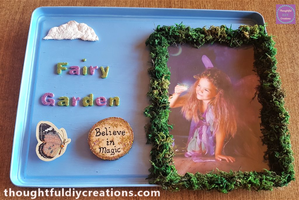 Hot glue added to the mid-section on the back of the wood slice and attached to the fairy garden lid.