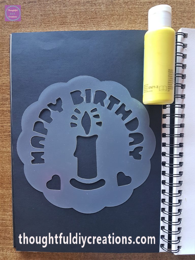 Stencil in the middle of the Page and Yellow Acrylic Paint.