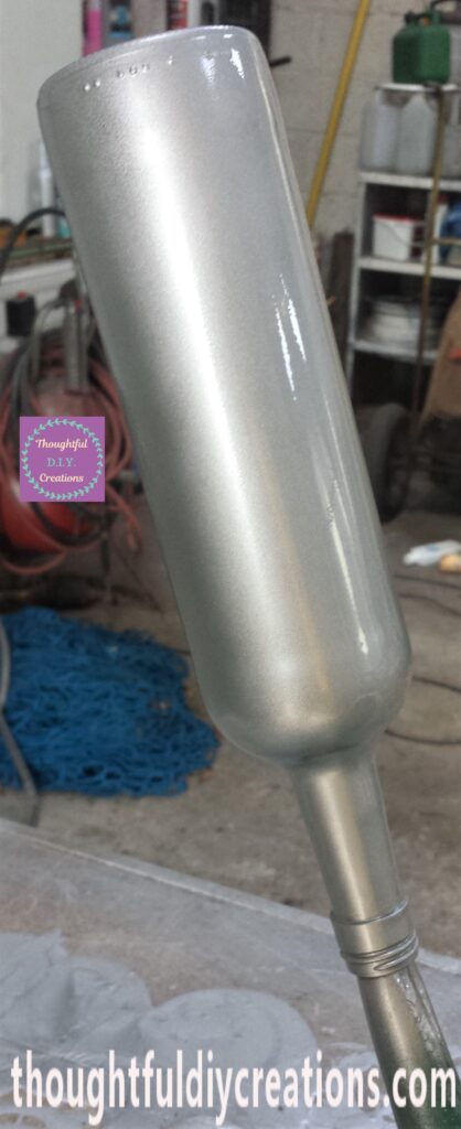 The second layer of spray paint applied to the bottle.