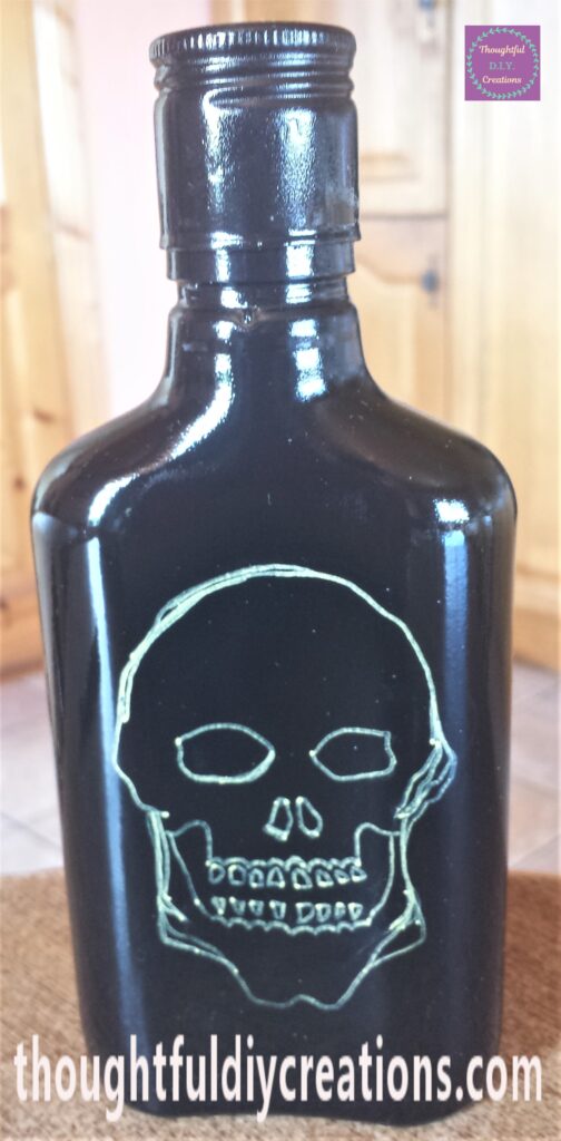 The outline of a Skull drawn on the Bottle with the Gold Paint Pen.