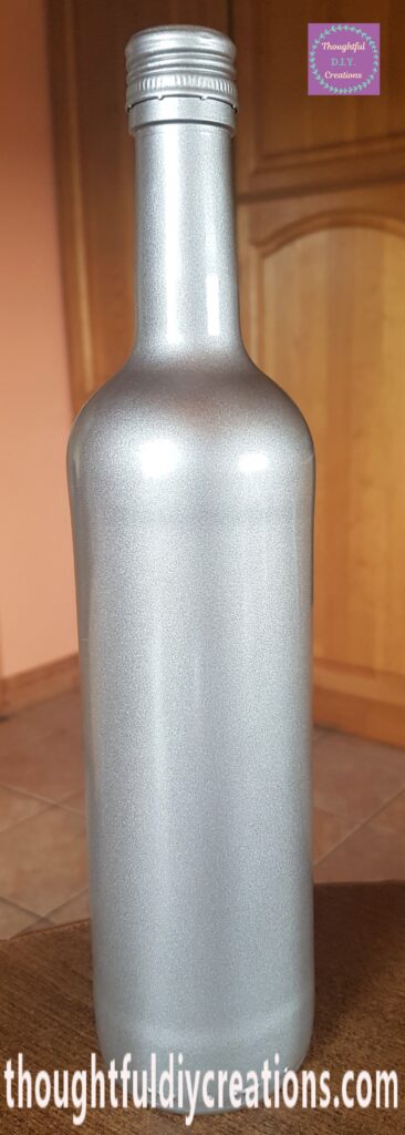 The bottle and lid brought back inside. The lid on the bottle.