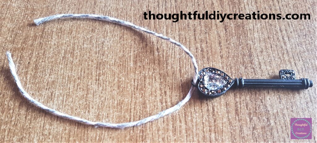 Grey and White Cord cut and put through the hole in the key.