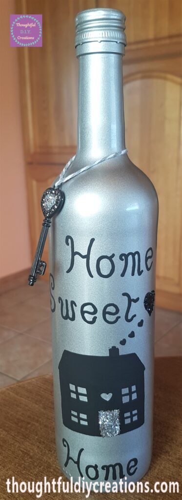 The key and string over the neck of the up-cycled wine bottle.