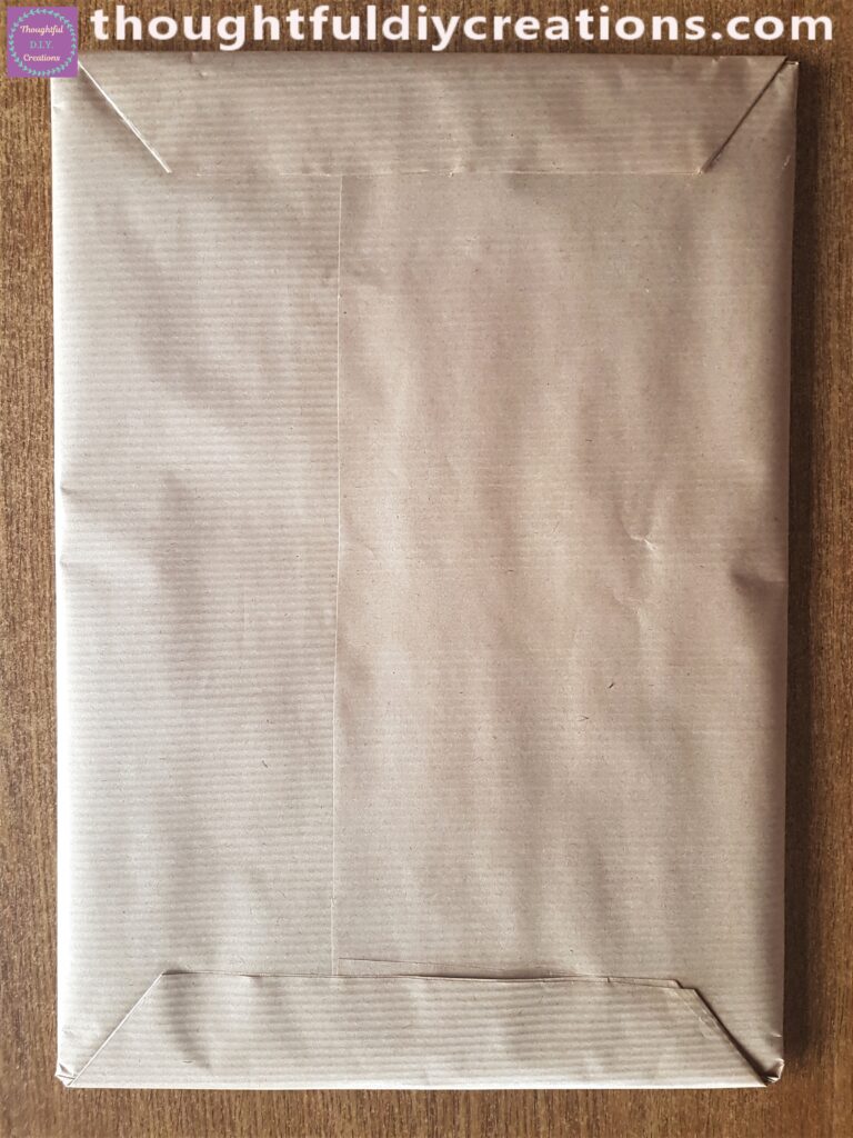 Top and bottom corners folded in and glued with Pritt Stick to the back of the Cardboard Base.