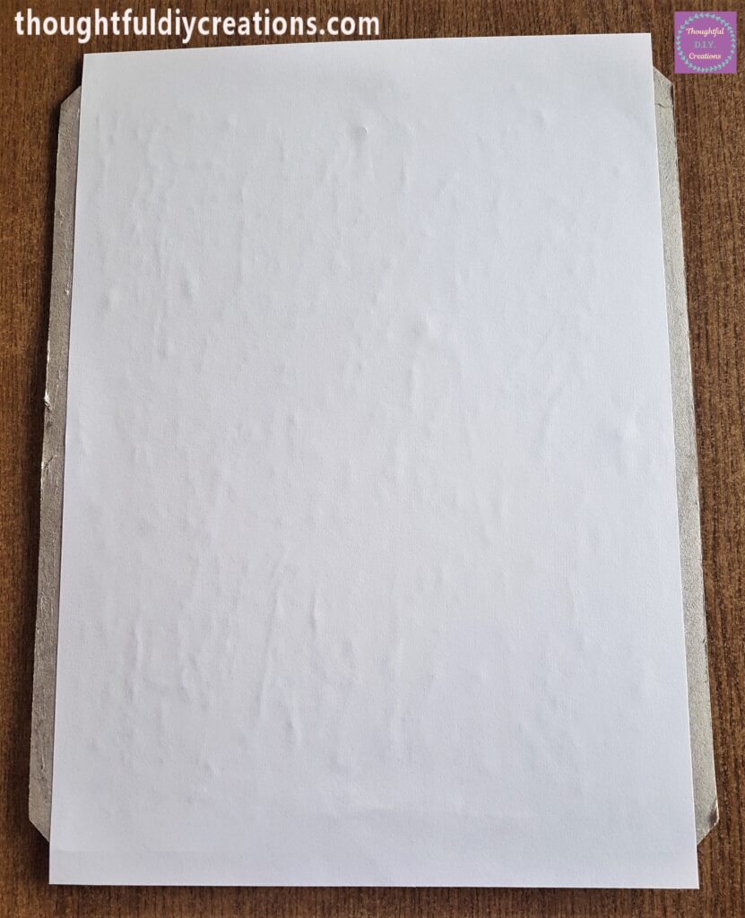 An A4 White Sheet of Paper attached to the Pritt Stick on the backing board.