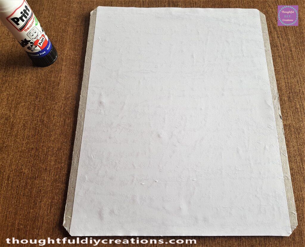 Pritt Stick all over the White Sheet and edges of the Backing Board.