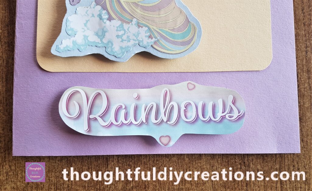 Hot Glue added to the Cardboard on the word 'Rainbows' and attached it to the bottom of the Card.