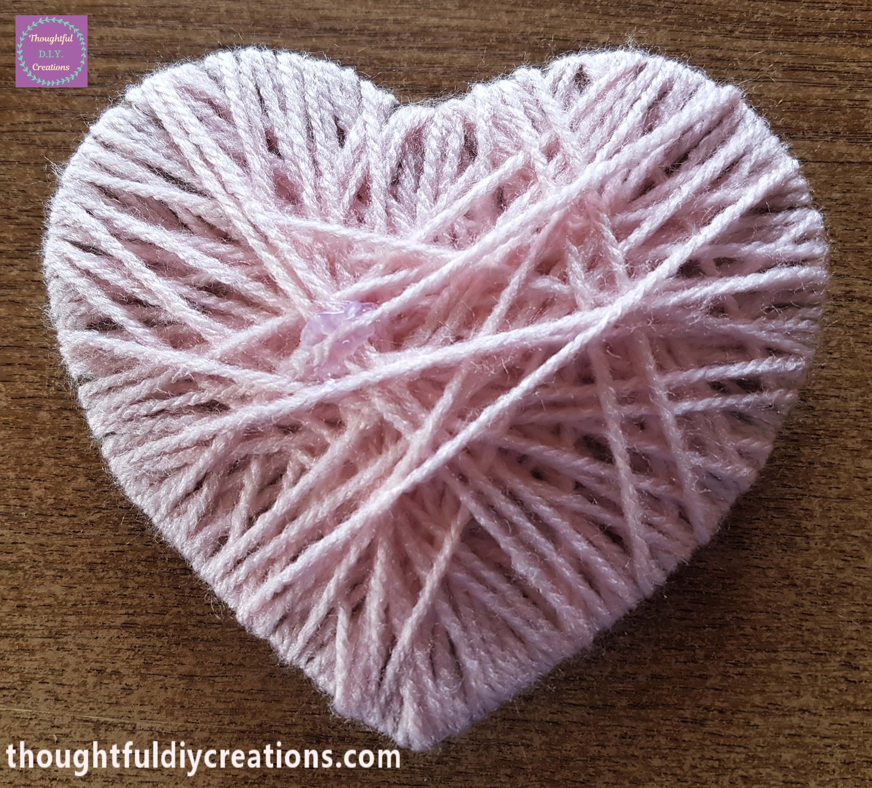 A knot and loop in the wool cut off, the wool hot glued to the back of the heart.