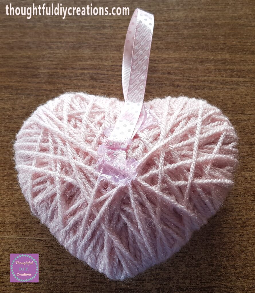 Hot Glue along the top mid-section of the Wool Heart and attached the ribbon to the glue.