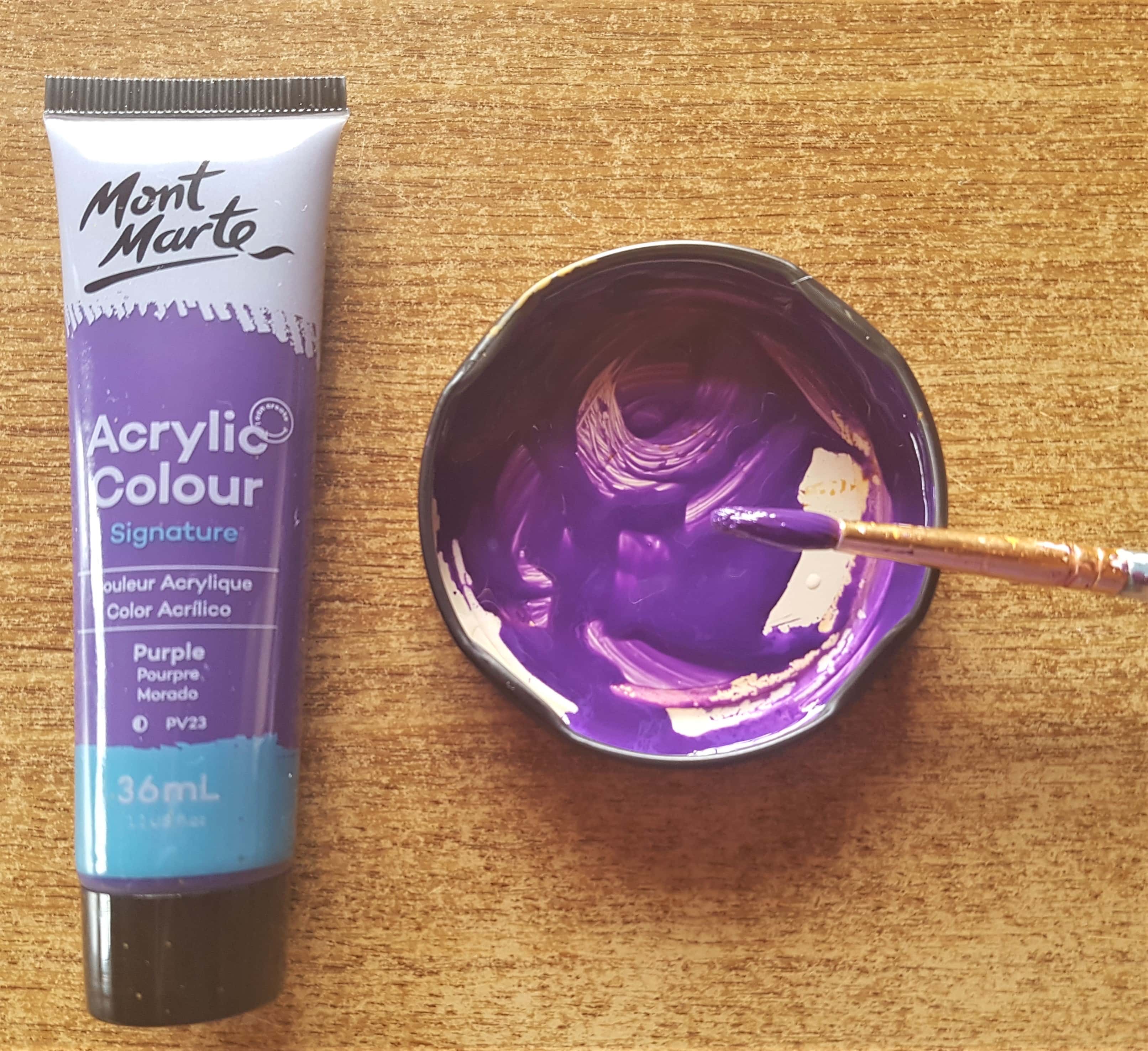 Purple Acrylic Paint added to the lid, water added and mixed with the paint using a paintbrush.