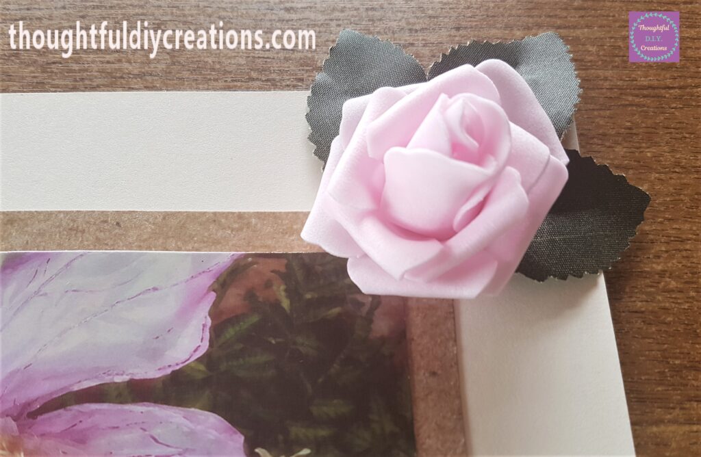 Hot Glue on the bottom of the Pink Rose and held on top of the leaves.