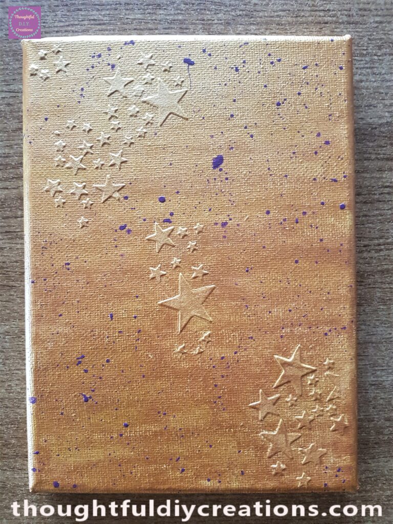 I removed the tissue from the canvas and allowed time for the paint splatters to dry.