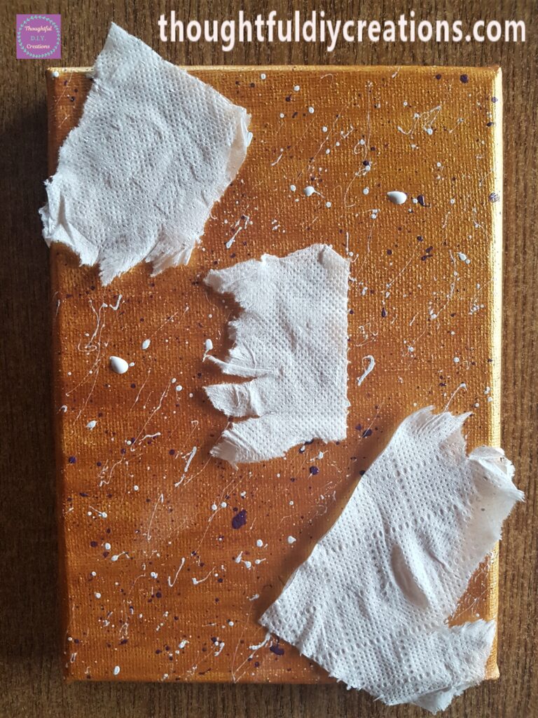 I covered up the stars and added white splatters to the canvas in the same way as the purple splatters.