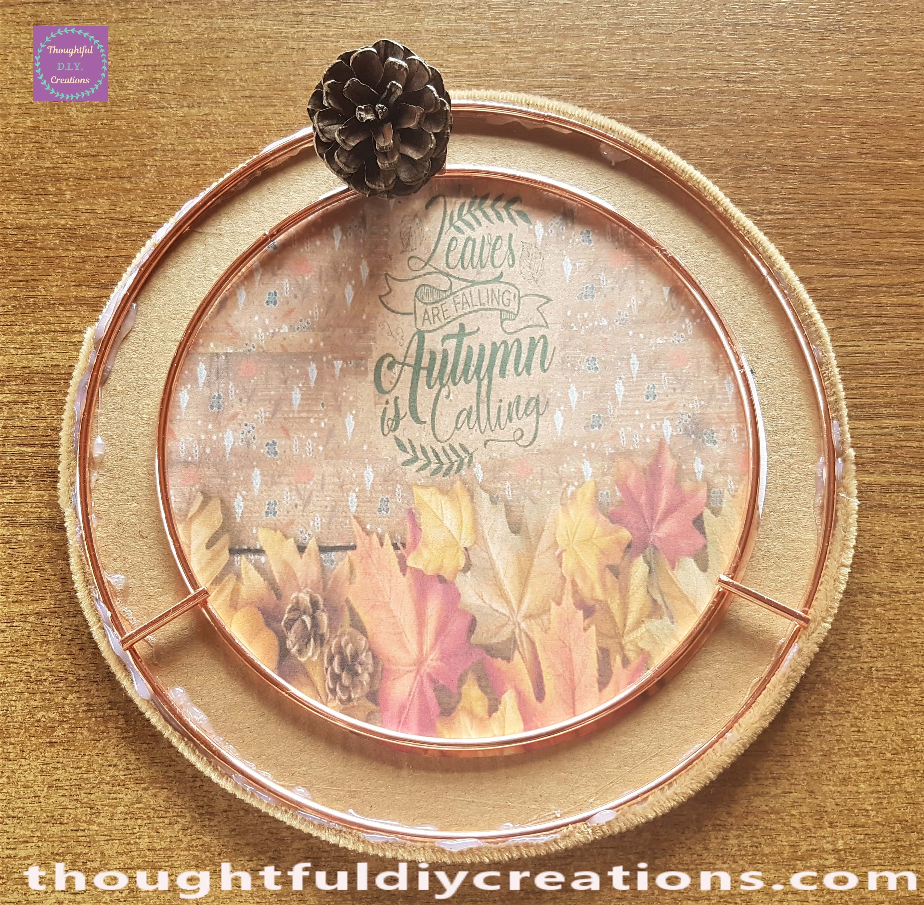 I put Hot Glue on the bottom of a Pine Cone and attached it to the Wreath.