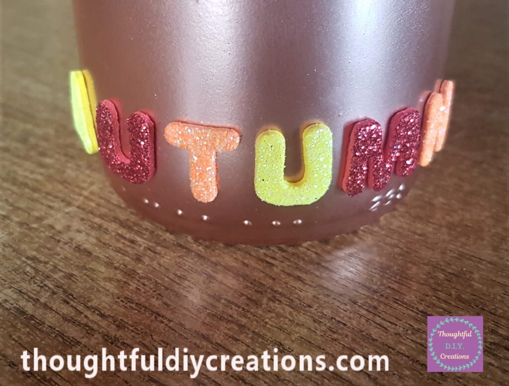 I removed the backing from the stickers and attached the Word AUTUMN to the bottom of the Bottle.