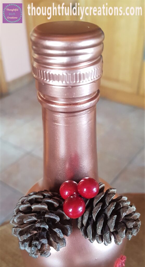 I put a dab of hot glue on the stem and attached each berry in between the 2 pine cones.