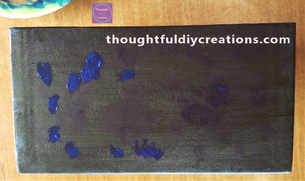 I started with the top side of the box and put blobs of blue paint in random areas with a small, flat paintbrush.