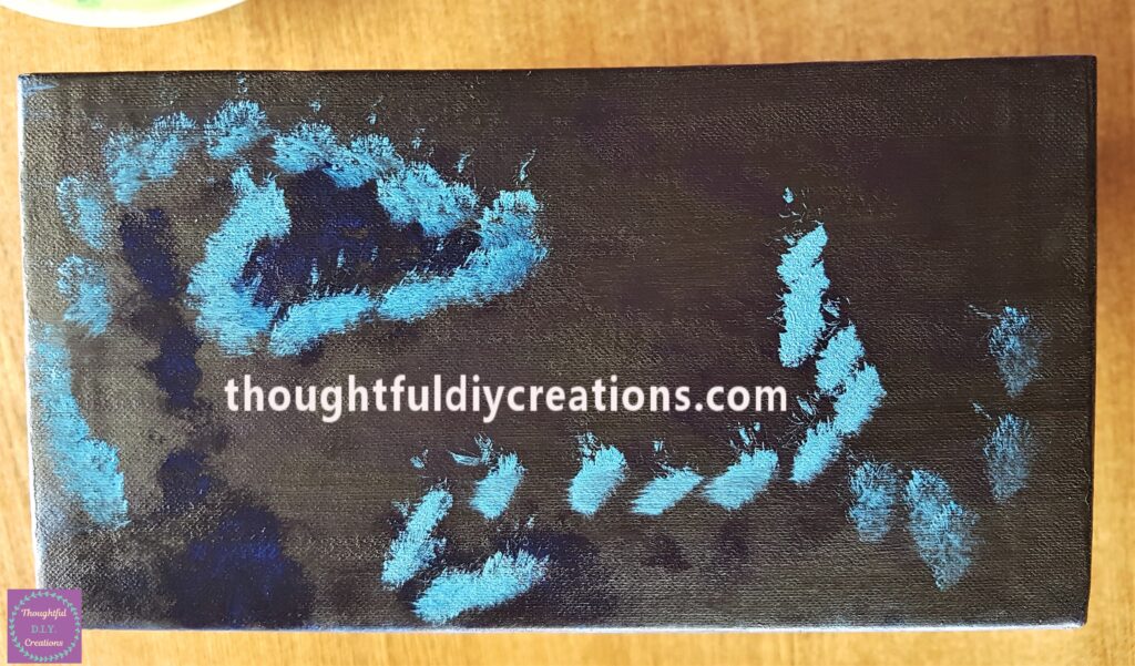 I added white paint to the dark blue and mixed them together. I put blobs of the light blue paint onto the box.