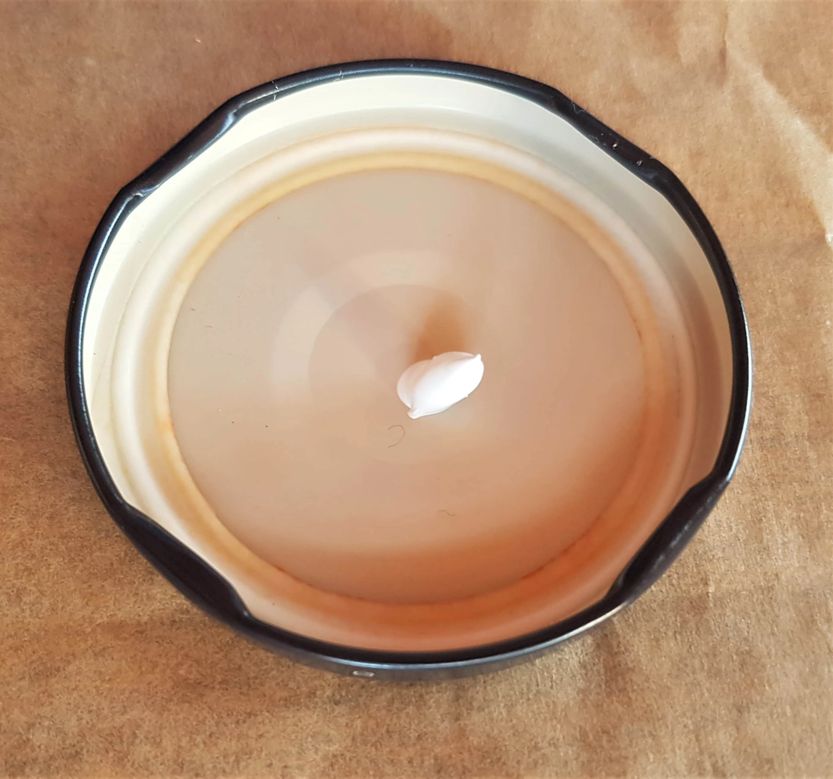 A blob of white acrylic paint in a lid.