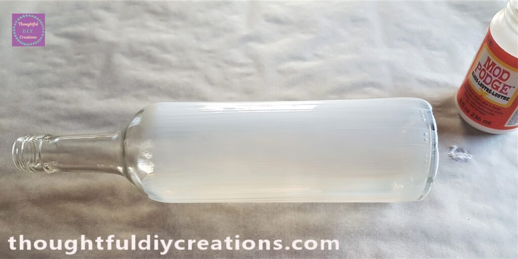 I put the Mod Podge Gloss onto the Wine Bottle with the Paintbrush.