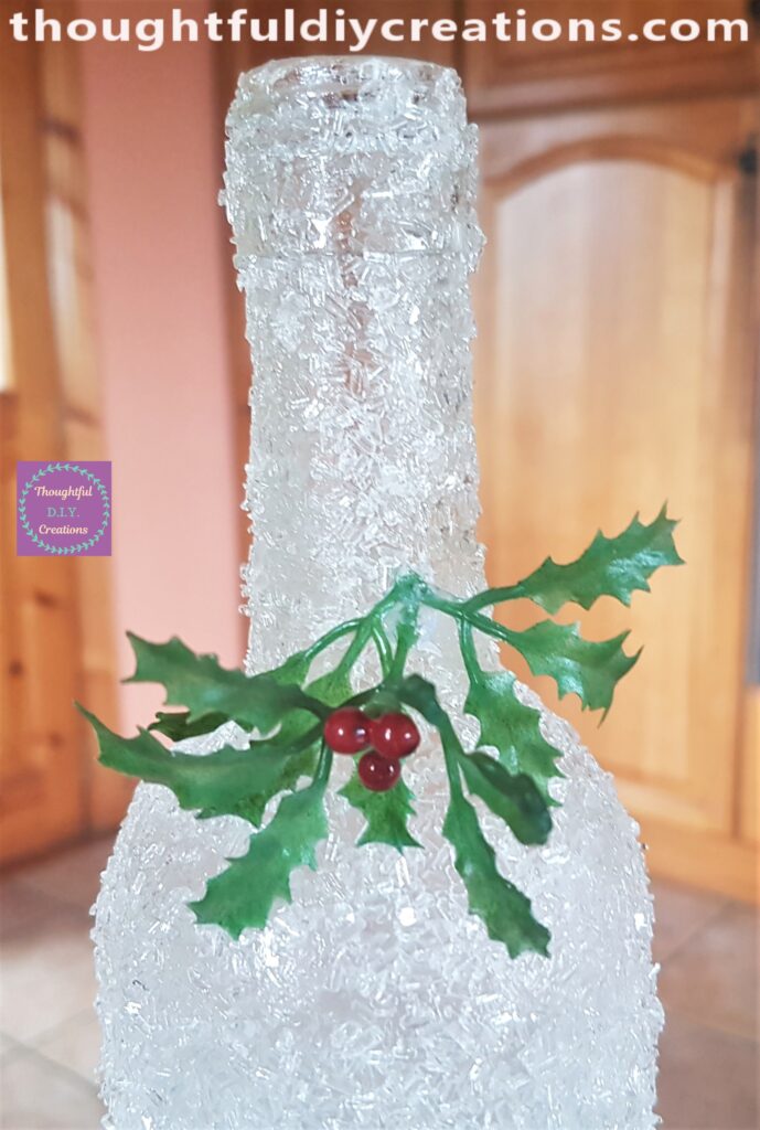 I put a dab of hot glue on the end of the Holly and attached it to the neck of the bottle.