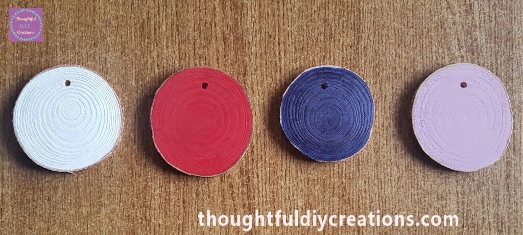 3 layers of white paint on a wood slice. one layer of the other colours onto the 3 other wood slices.