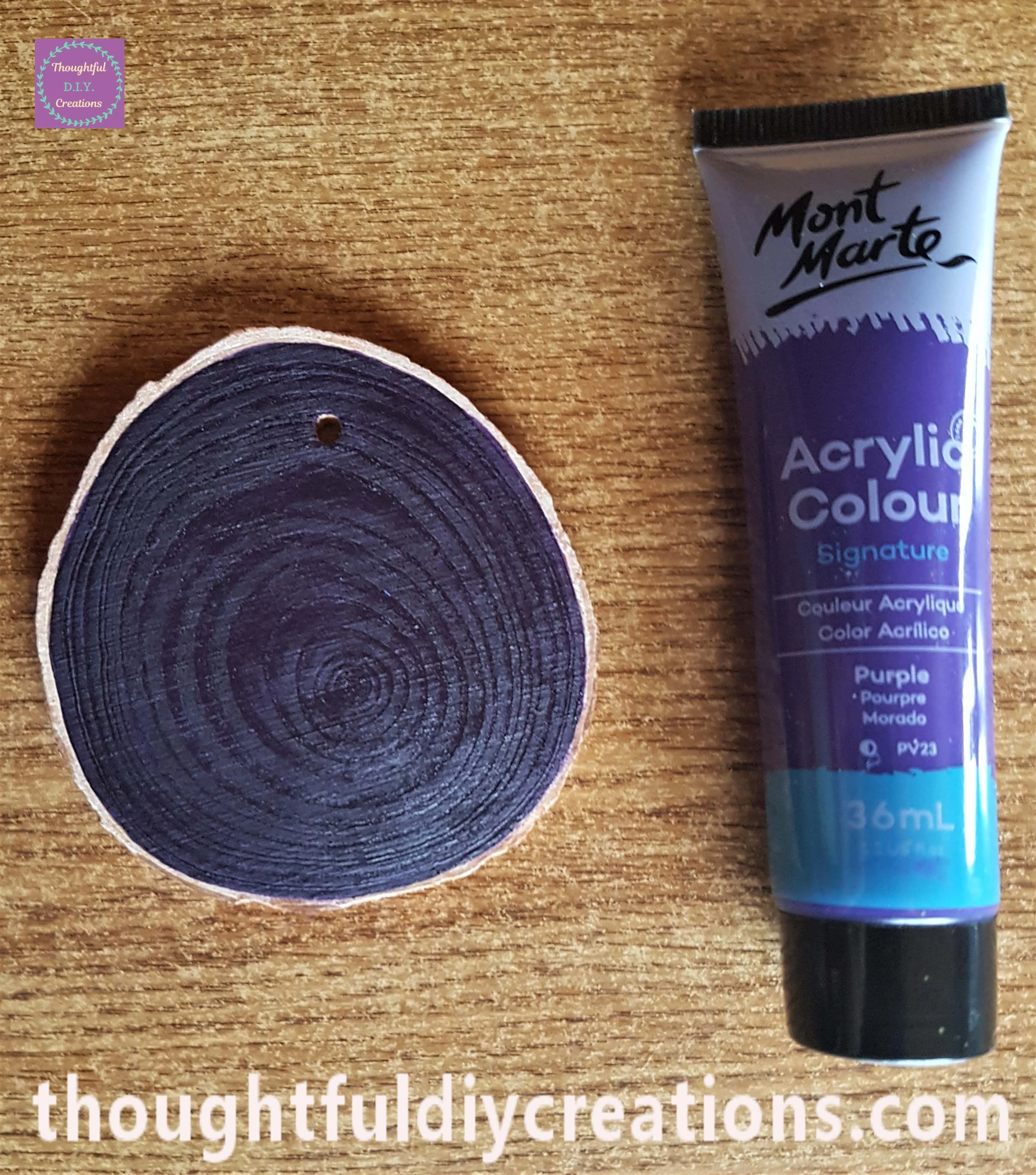 2 layers of purple paint onto another wood slice.