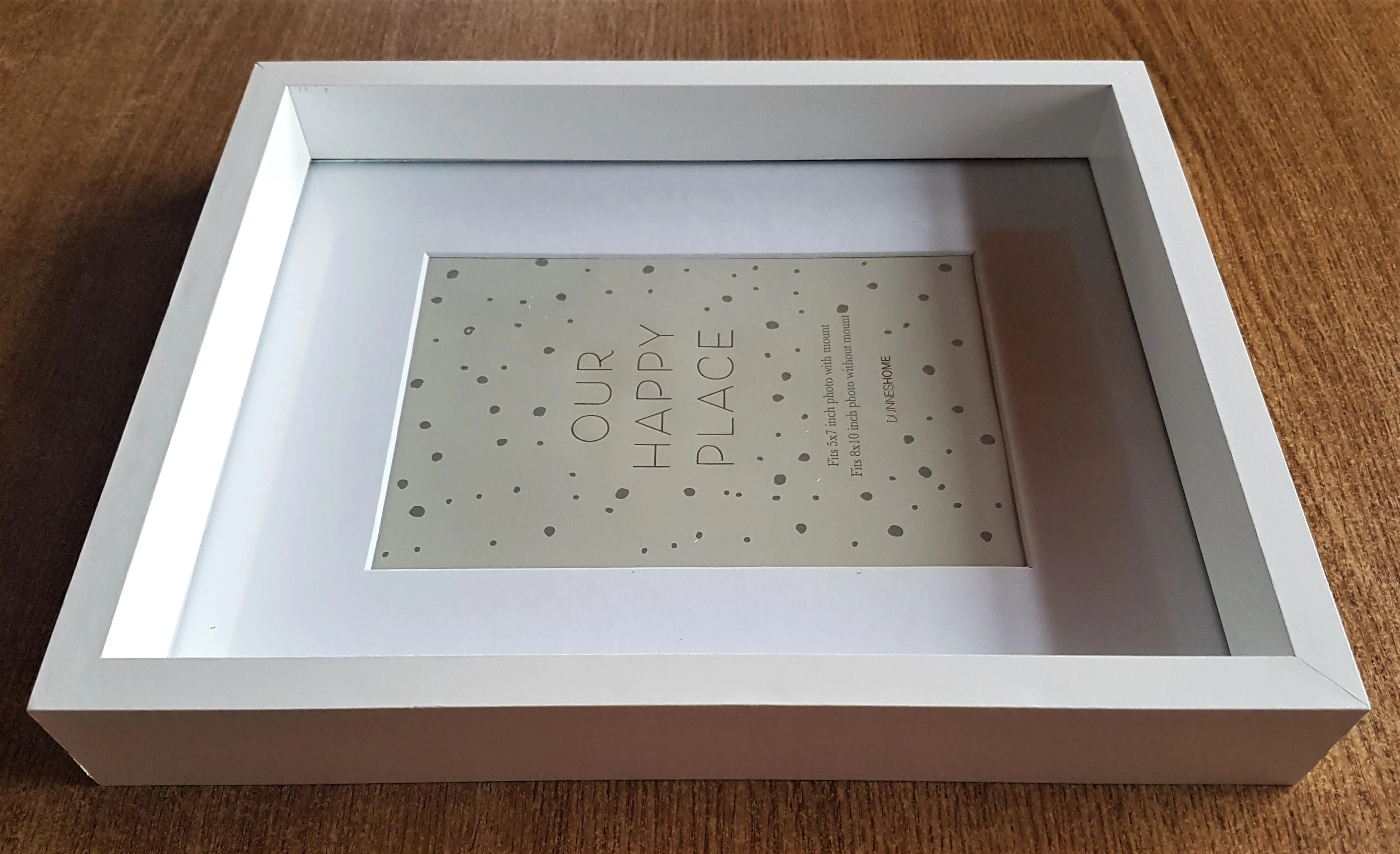 White Shadow Box Frame measuring 8 and 3/4 inches by 10 and 3/4 inches.