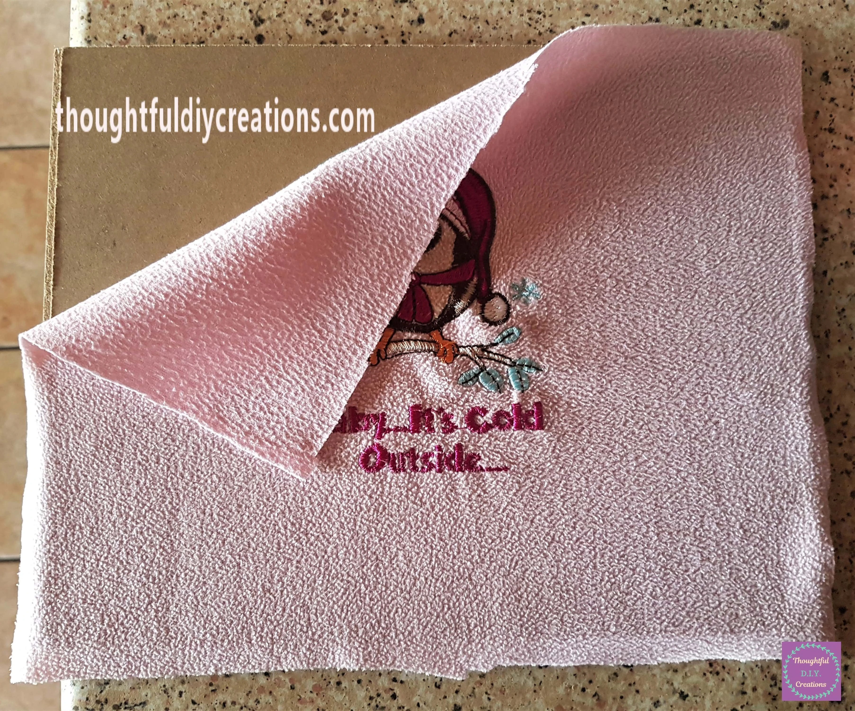 I plugged in my hot glue gun. I placed the fabric on the backing board and turned the top left corner back.