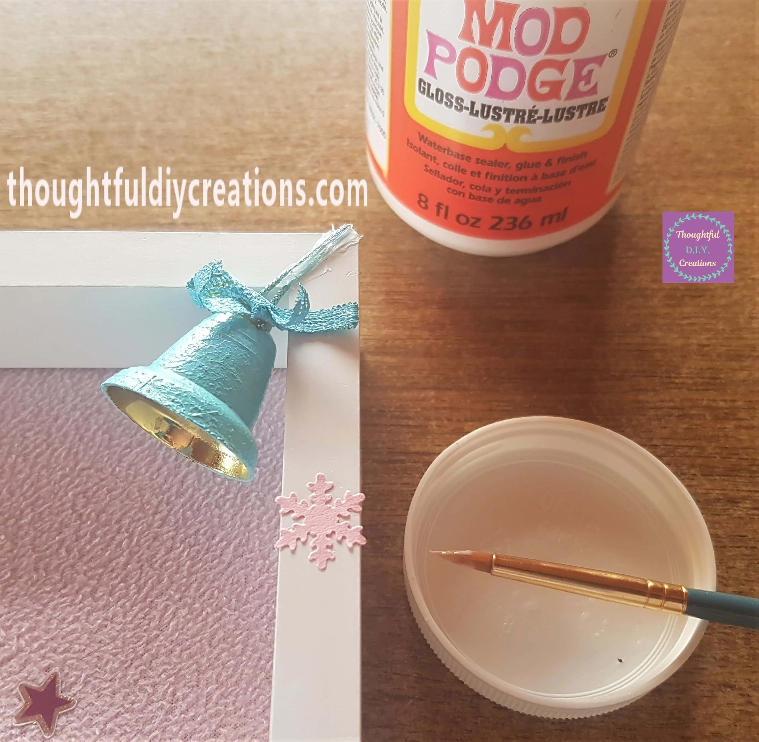 Mod Podge onto the back of a pink snowflake and attached it to the right side of the frame.